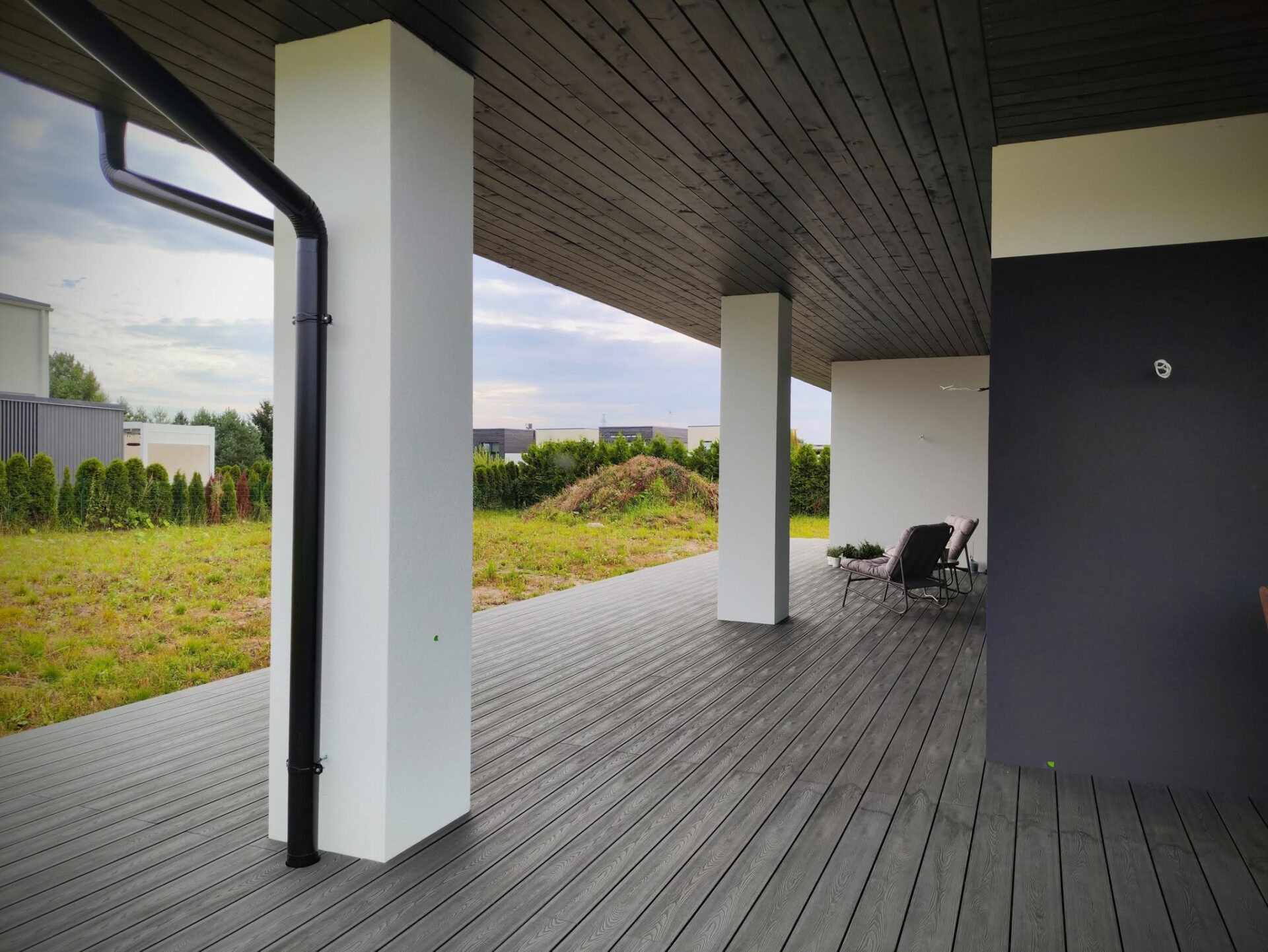 Tume WPC-terrass modernse hoone katusealusel